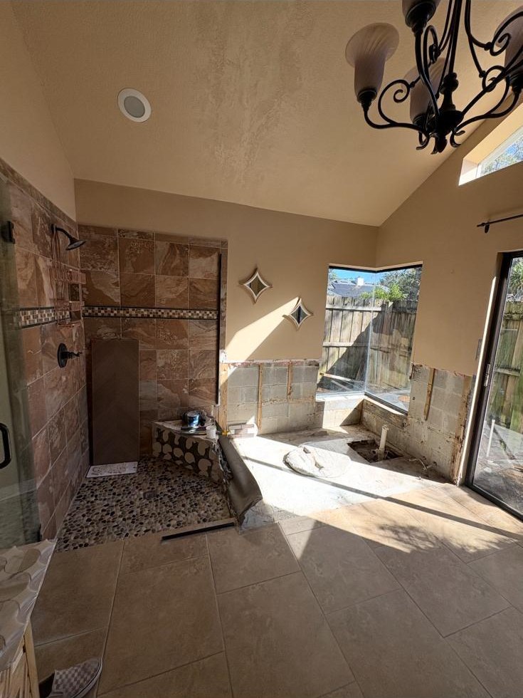 Primary bathroom renovation: dated tile shower and drop-in tub replaced with a herringbone walk-in shower and freestanding tub — before