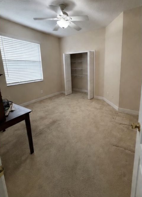 Bedroom carpet replaced with wood-look laminate flooring and fresh paint — before