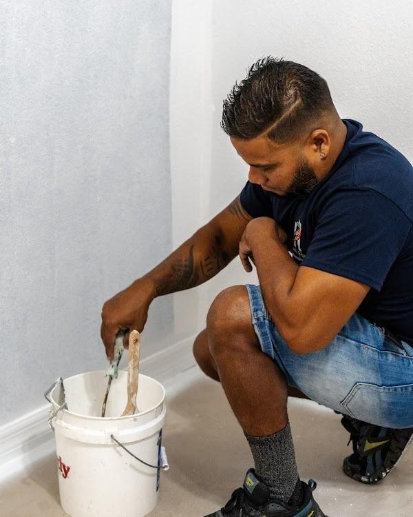 Hamlet loading a paint roller before rolling a fresh coat on an interior wall