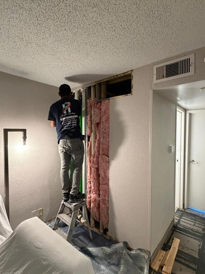 Hilton hotel room wall opened for drywall repair, then patched, textured and repainted — before